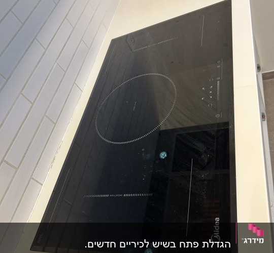 כיריים אינדוקציה מותקנים על משטח שיש במטבח